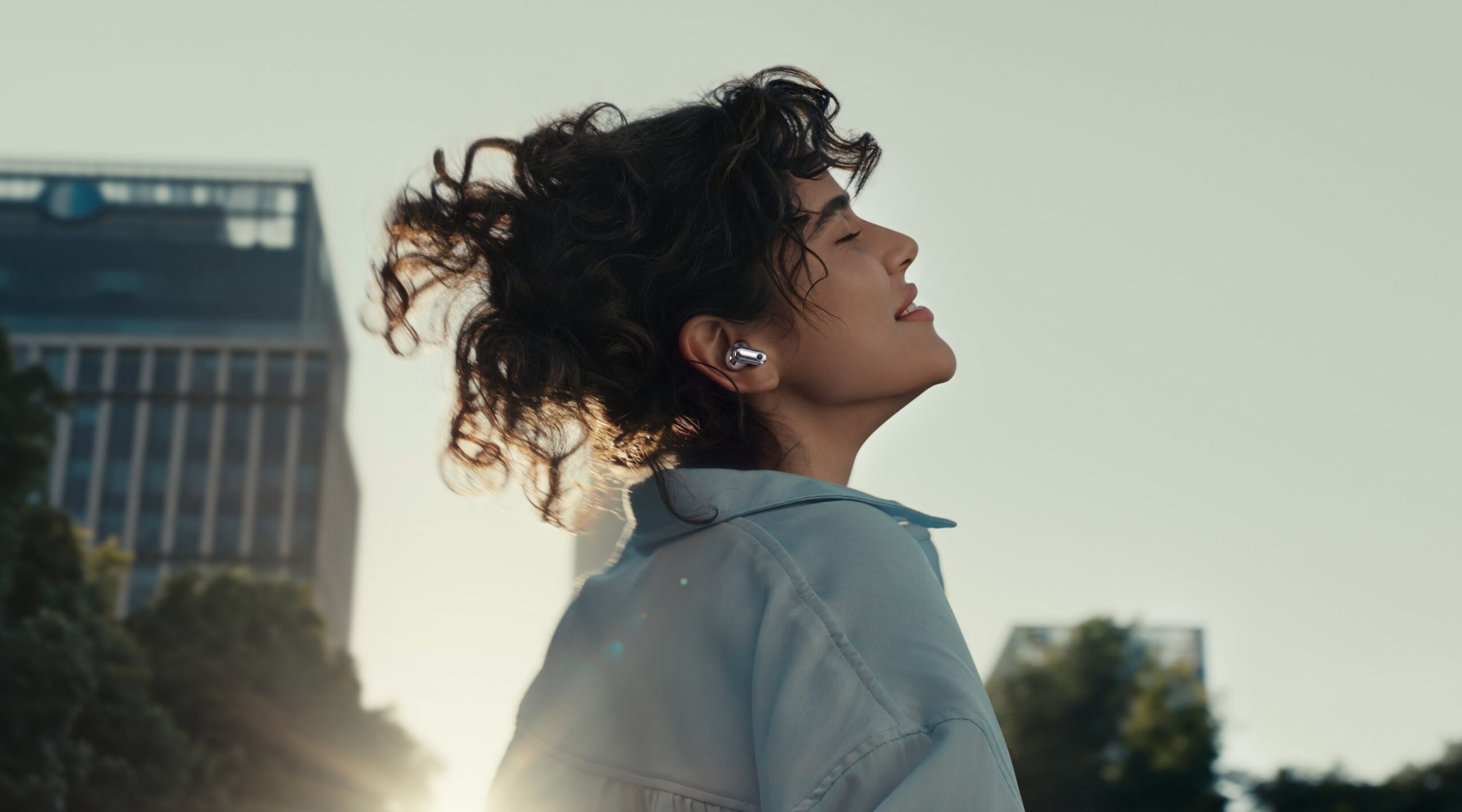 HUAWEI FreeBuds Neoを着けて街を歩く女性